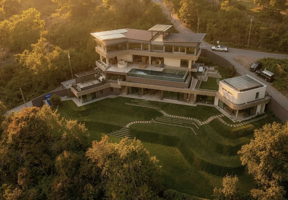 Luxury tropical villa surrounded by green hills at sunset