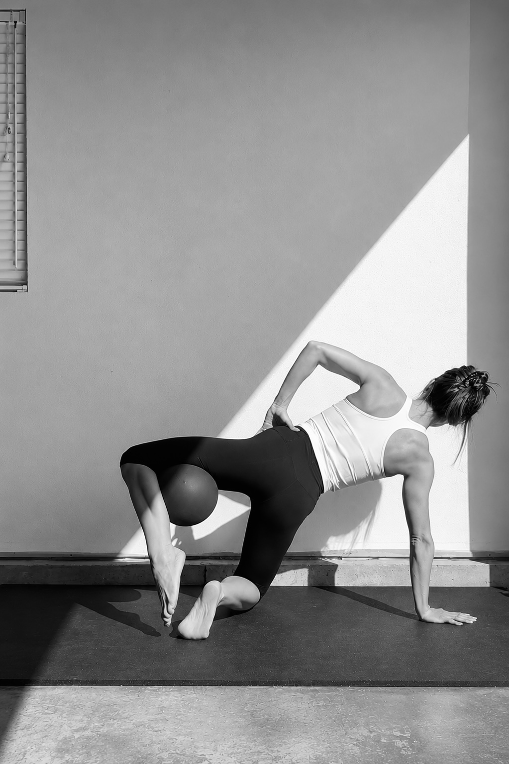 Woman practising a controlled Pilates hip and core movement
