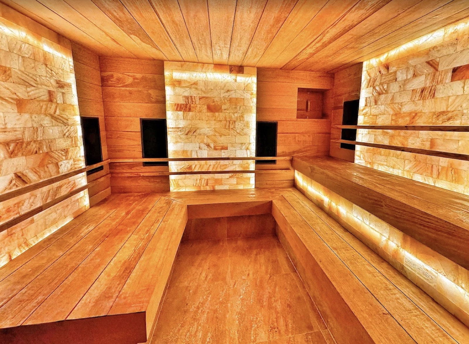 Warm wood and illuminated stone sauna interior